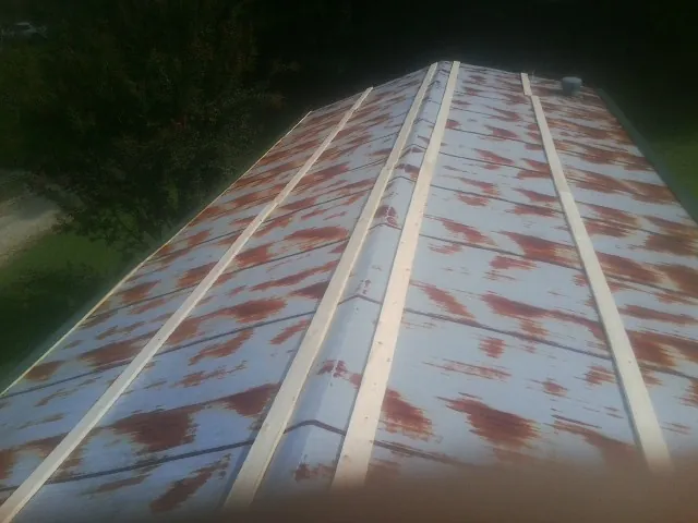 Rusted metal roof panels with new wood purlins before replacement — Storm Damage Roof Repair in North Garden by Roofing Brothers