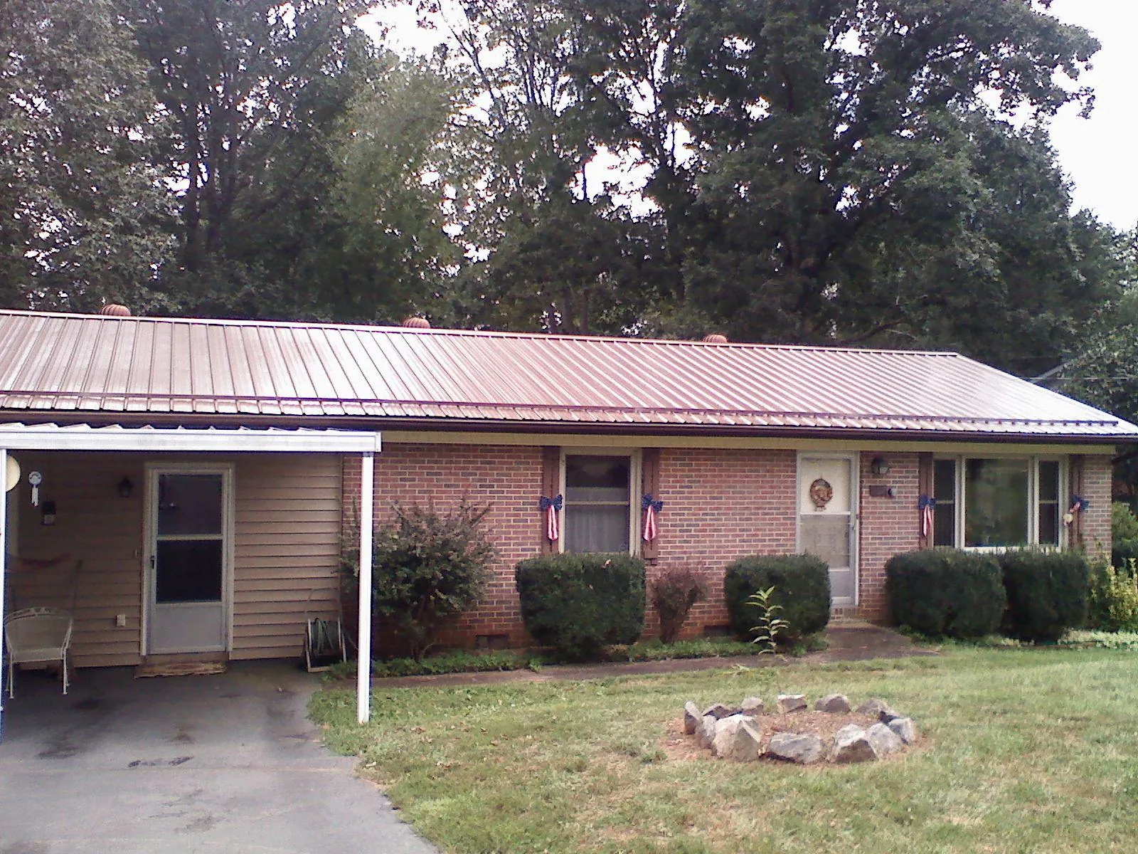 Bronze metal roof and carport on a brick ranch home — Roof Repair work by our crew in North Garden